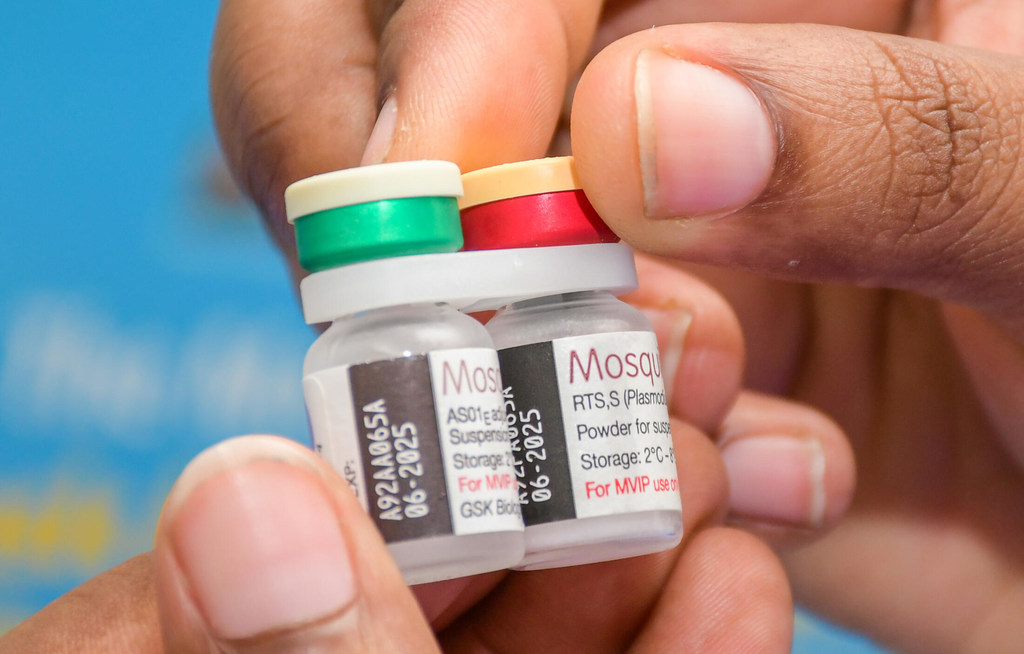 Un trabajador sanitario de Kenia sostiene viales de vacuna contra la malaria o paludismo para su administración en una campaña de vacunación.